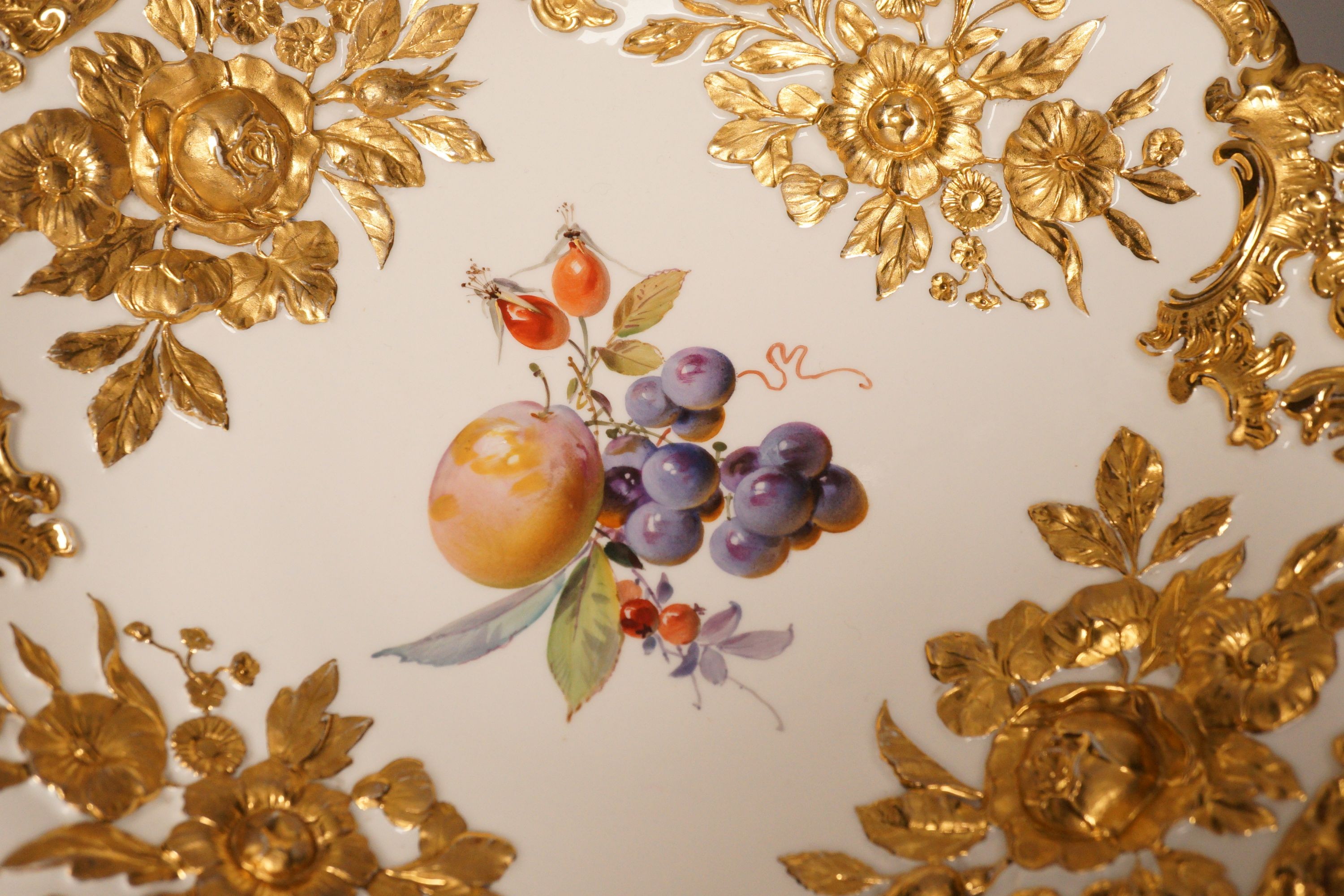 An early 20th century century Meissen fruit and floral gilt motif dish, 30cm diameter